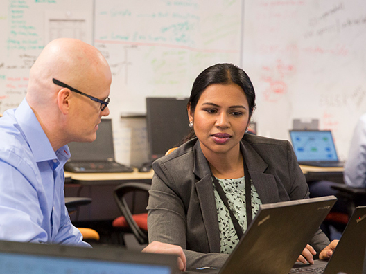 Female and male colleagues discuss a work project.