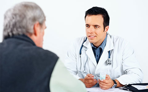 Doctor wearing stethoscope and lab coat advises truck driver