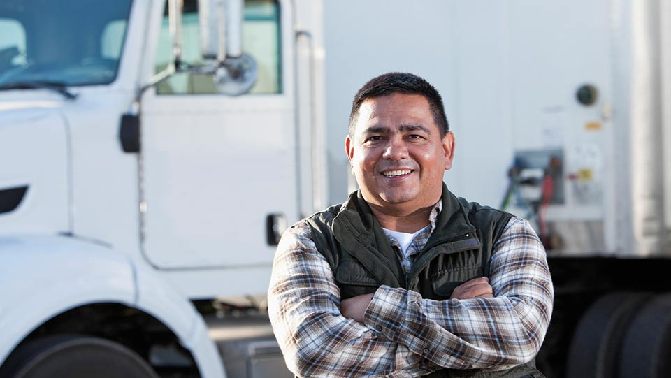 Driver standing in front of a truck.