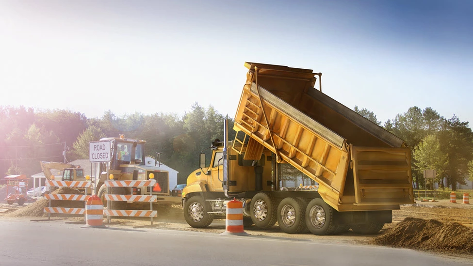 dump truck unloading - road closed sign