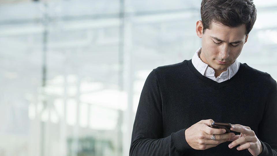 Employee checking his phone for email communication