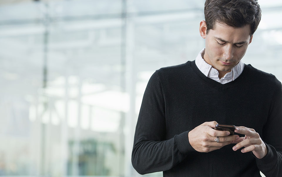 Employee checking his phone for email communication.