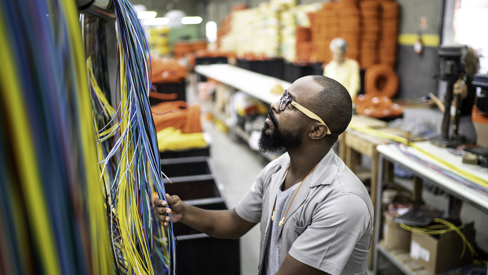 Employee working with wires in manufacturing.