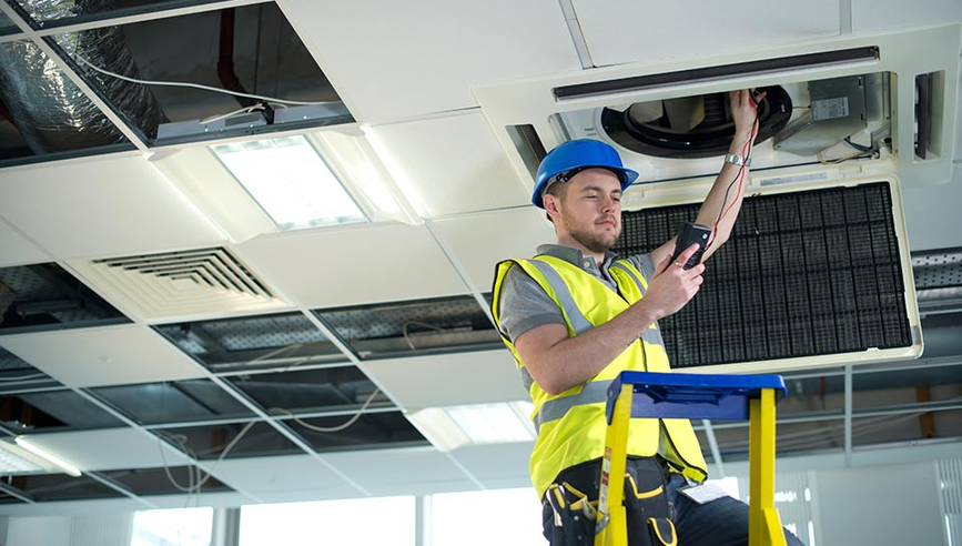 facility worker managing risk inspecting ceiling