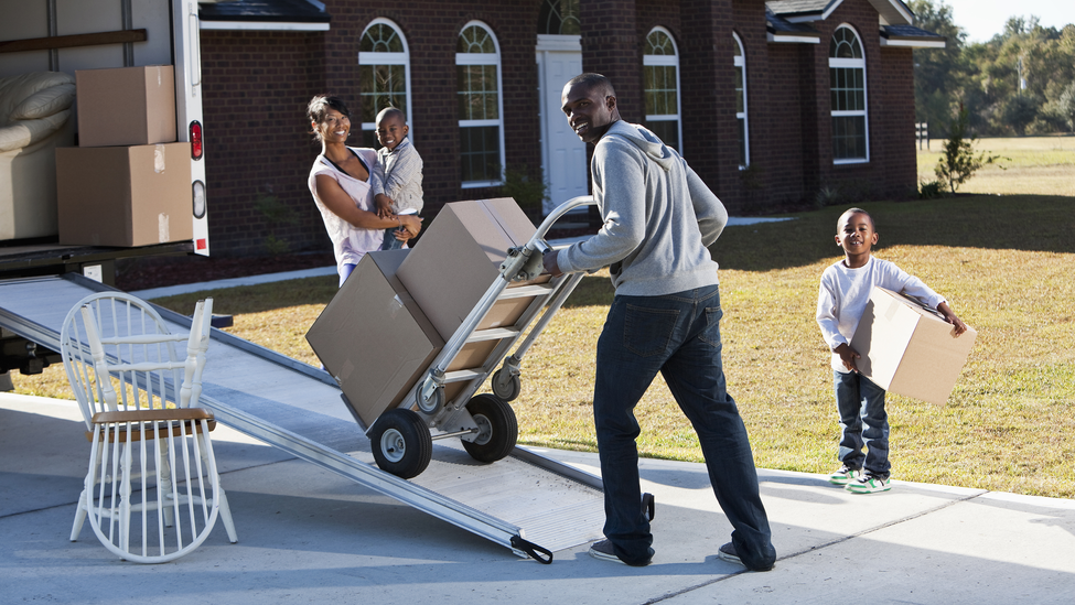 Family packing moving truck with boxes.