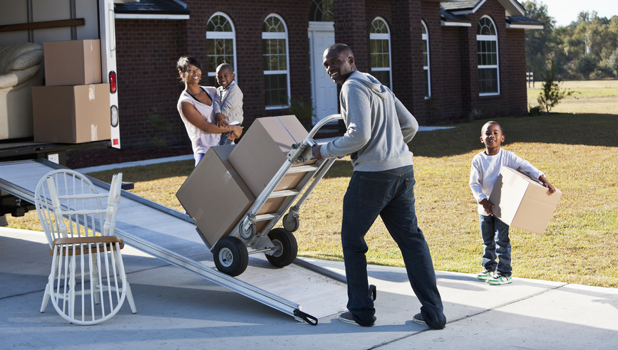 Family moving boxes on to a moving truck.