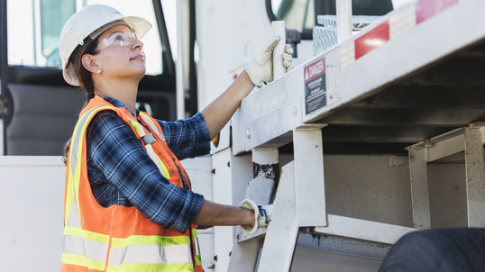 Female construction worker looking up at a lift.