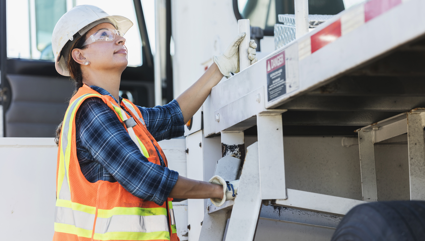 Female construction worker looking up at lift.