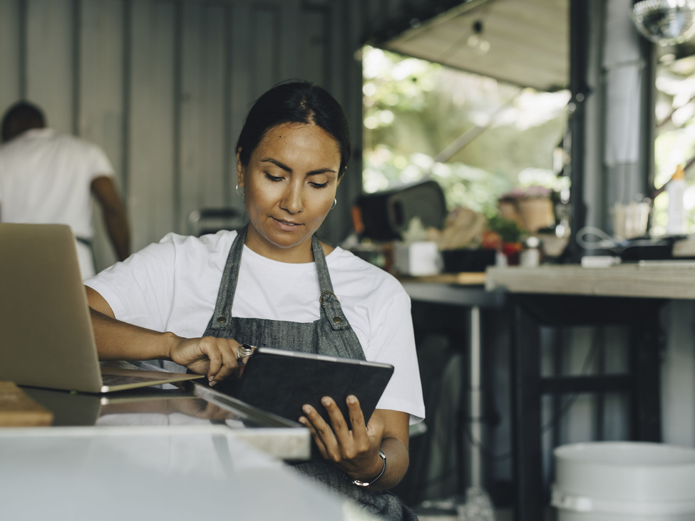 Small retail shop owner checks her insurance coverage on a tablet.