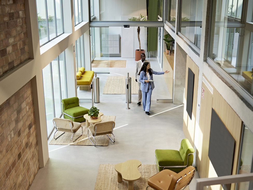 A woman and a client walking in an office lobby.