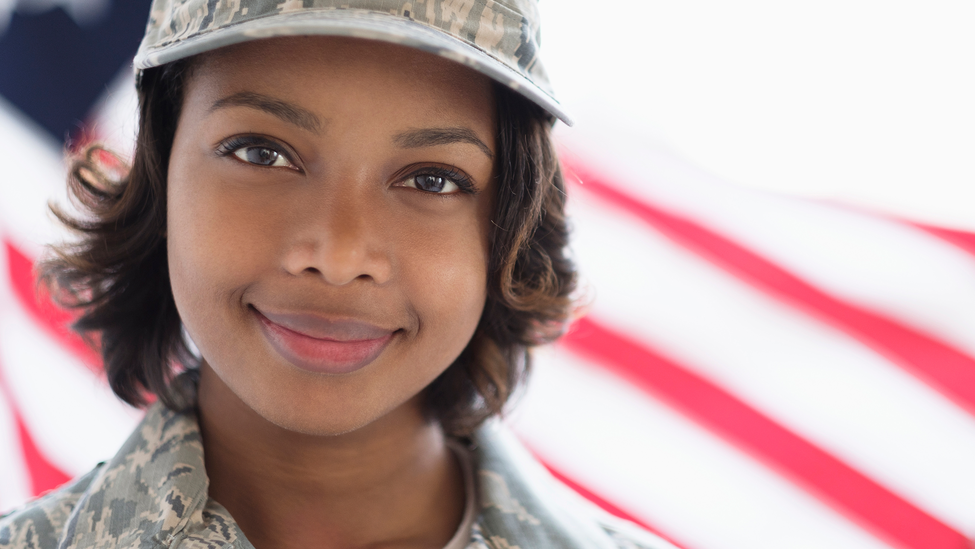 Headshot of a woman wearing military uniform standing in front of the American flag