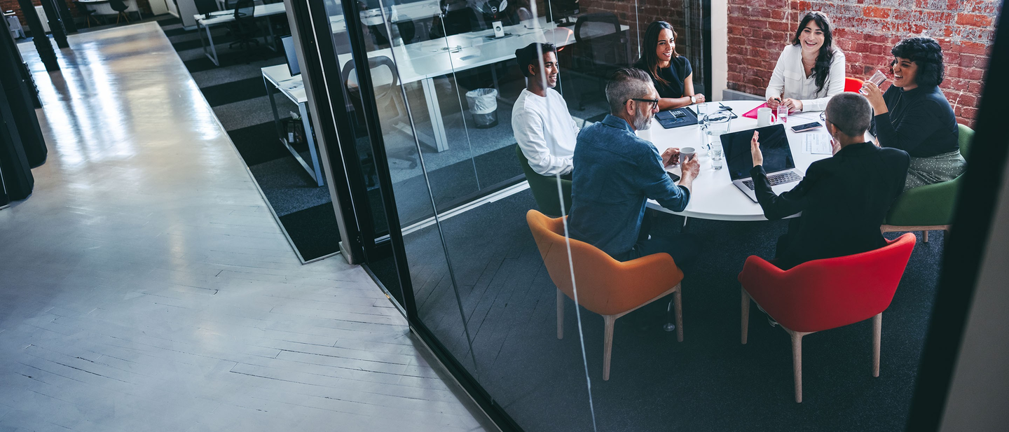 Business professionals discussing cyber security coverage in a modern conference room. 