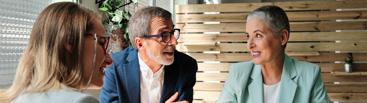 Financial advisor presents their plan to clients while sitting at a restaurant table.