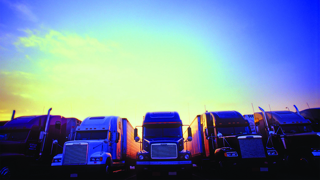 fleet of large semi trucks lined up in a row