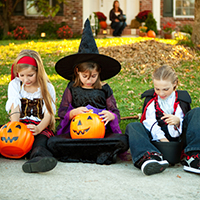 Four kids in Halloween costumes.