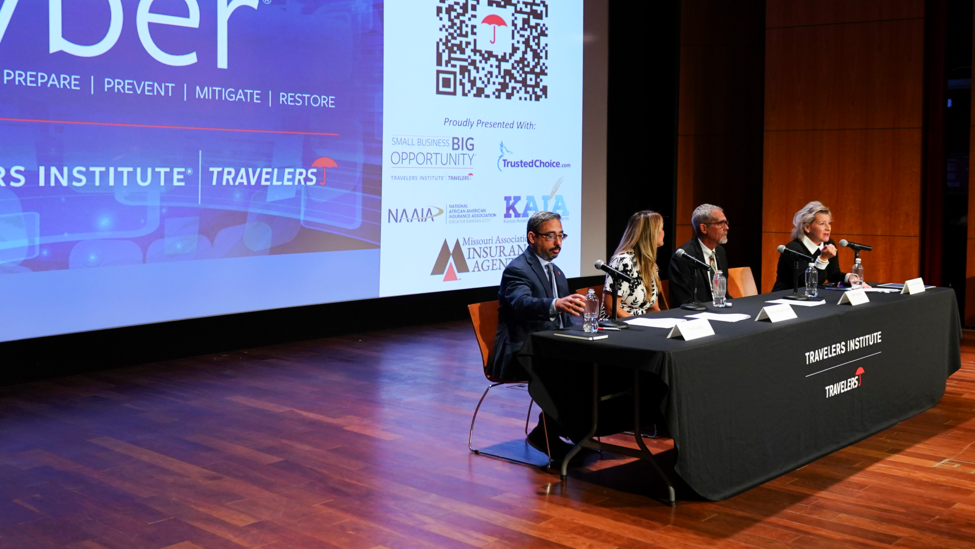 four-panelists-seated-on-stage-at-event.png