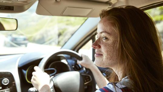 freckled-young-woman-driving-car-looking-sideways.jpg