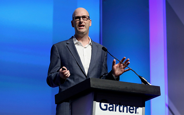 Man speaking at podium with Gartner