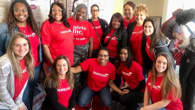 A group of individuals with Travelers shirts at an event.