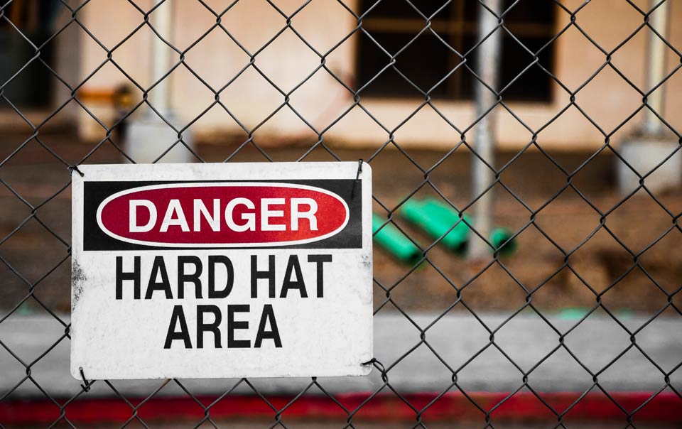 Hard hat area sign in front of construction site.