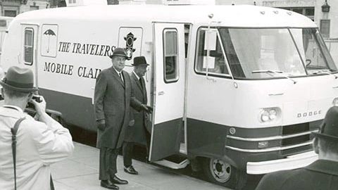 Two Travelers executives are photographed in 1968 whilst visiting the CAT Van mobile claim office, a modified caravan assisting policyholders after disasters.