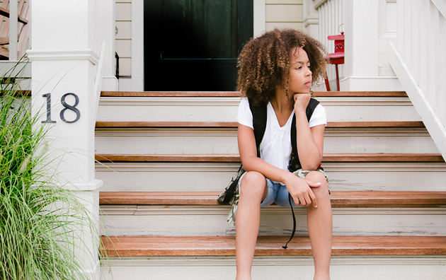 woman sitting in front of house.