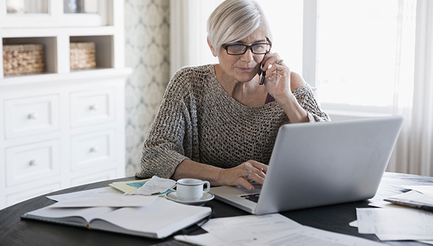 Woman on laptop calling to get a homeowners insurance quote.