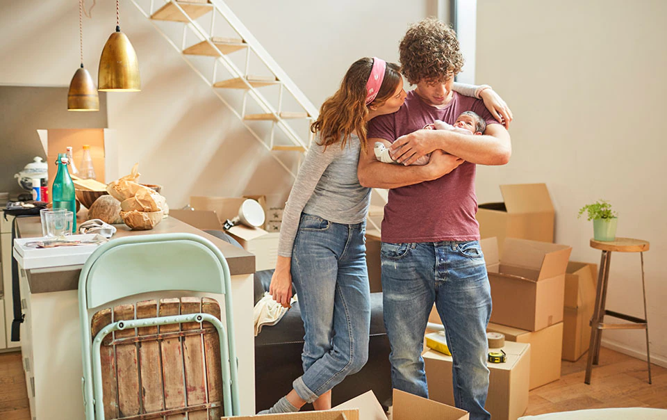 Young couple holding a baby in new home.