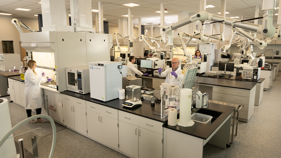 Scientist gazing into microscope.