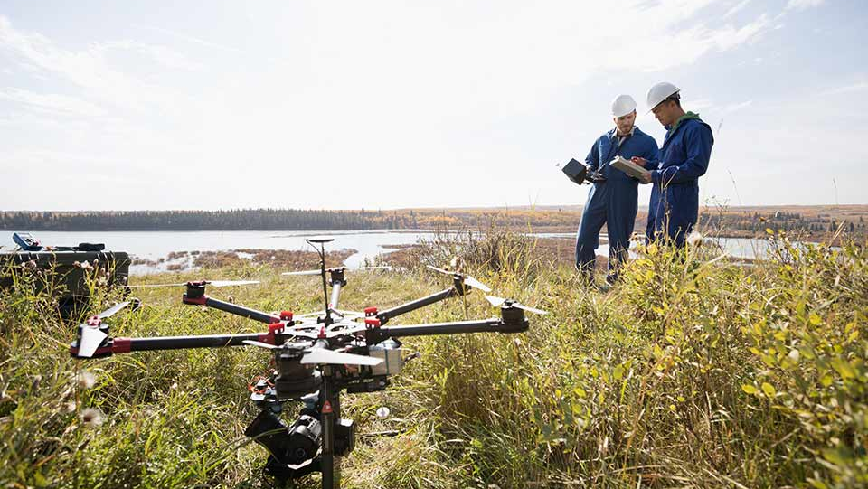 Commercial employees using drone to monitor land.
