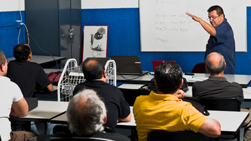 Instructor teaching in a classroom to group of adults