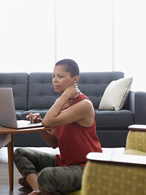 Homeowner reads about home insurance tips while sitting in her living room.