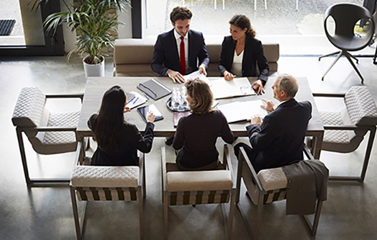 5 employees discussing on table 