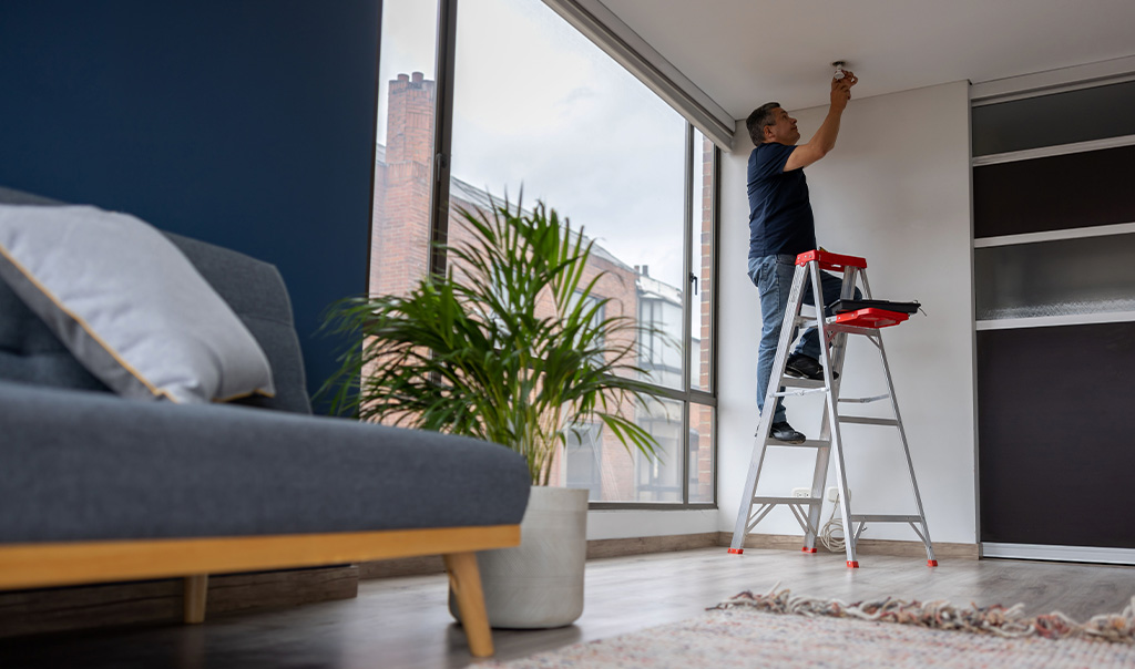 Landlord fixing a light bulb at an apartment 