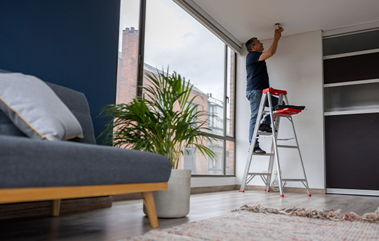Landlord fixing a light bulb at an apartment