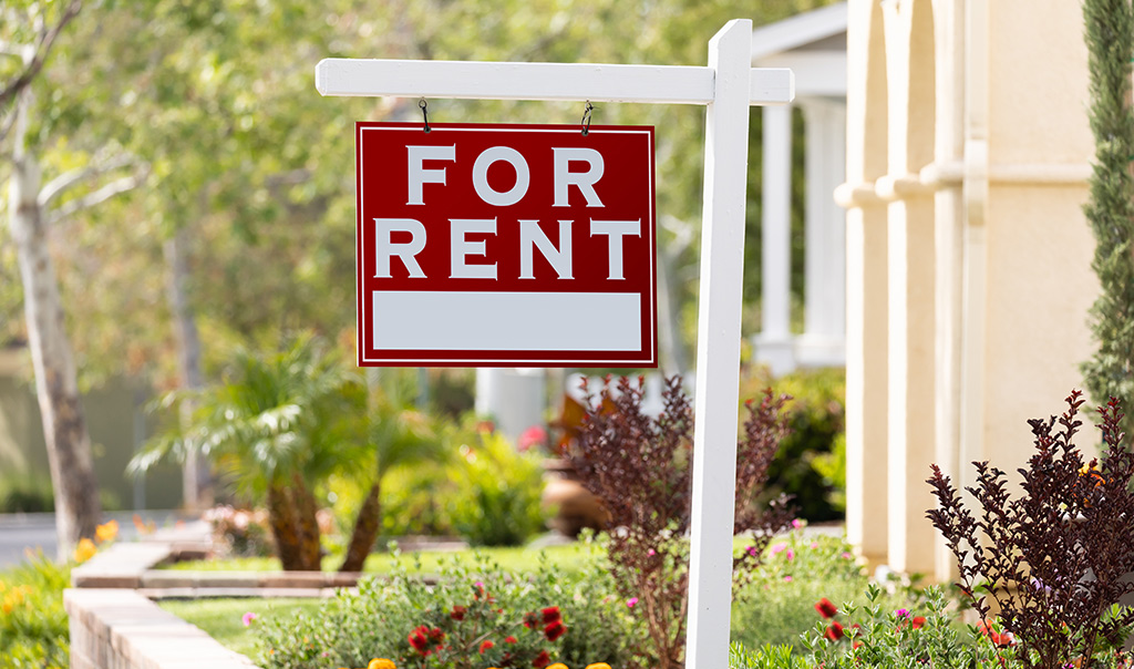 "For Rent" sign in front of a house.