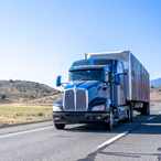 Large blue semi-truck driving on interstate