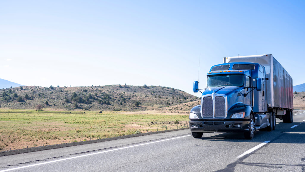 large blue semi driving on interstate