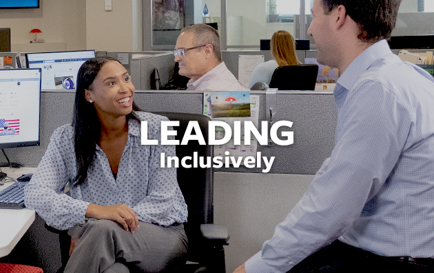 Diverse colleagues sitting in an office setting with text overlay reading "Leading Inclusively".