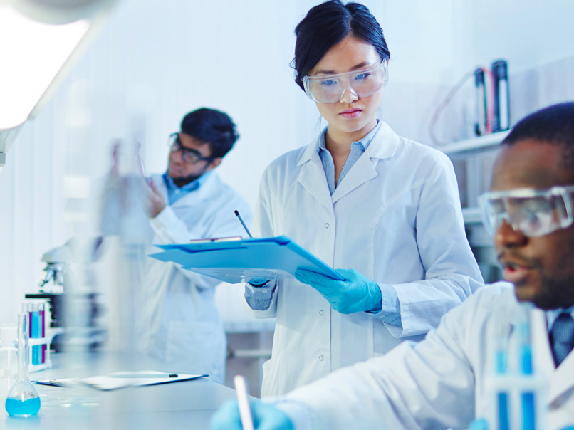 Three scientists working in lab.