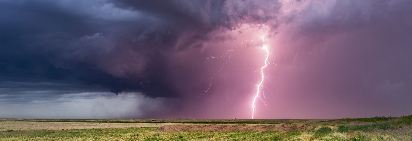 Lightning strikes in an open field.