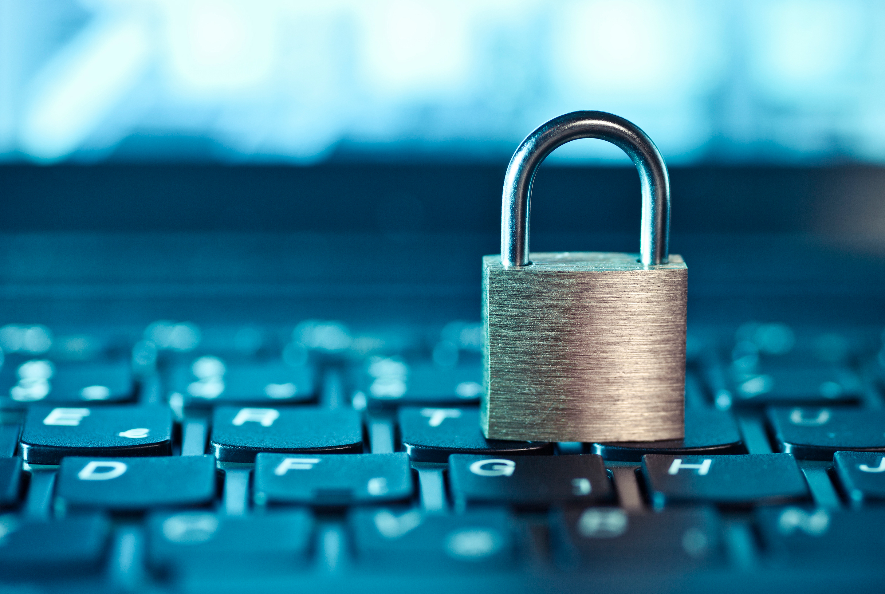 Lock resting on keyboard, representing cyber security.