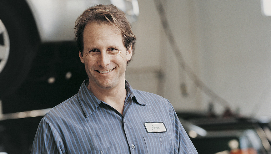 auto or truck mechanic in a shop smiling