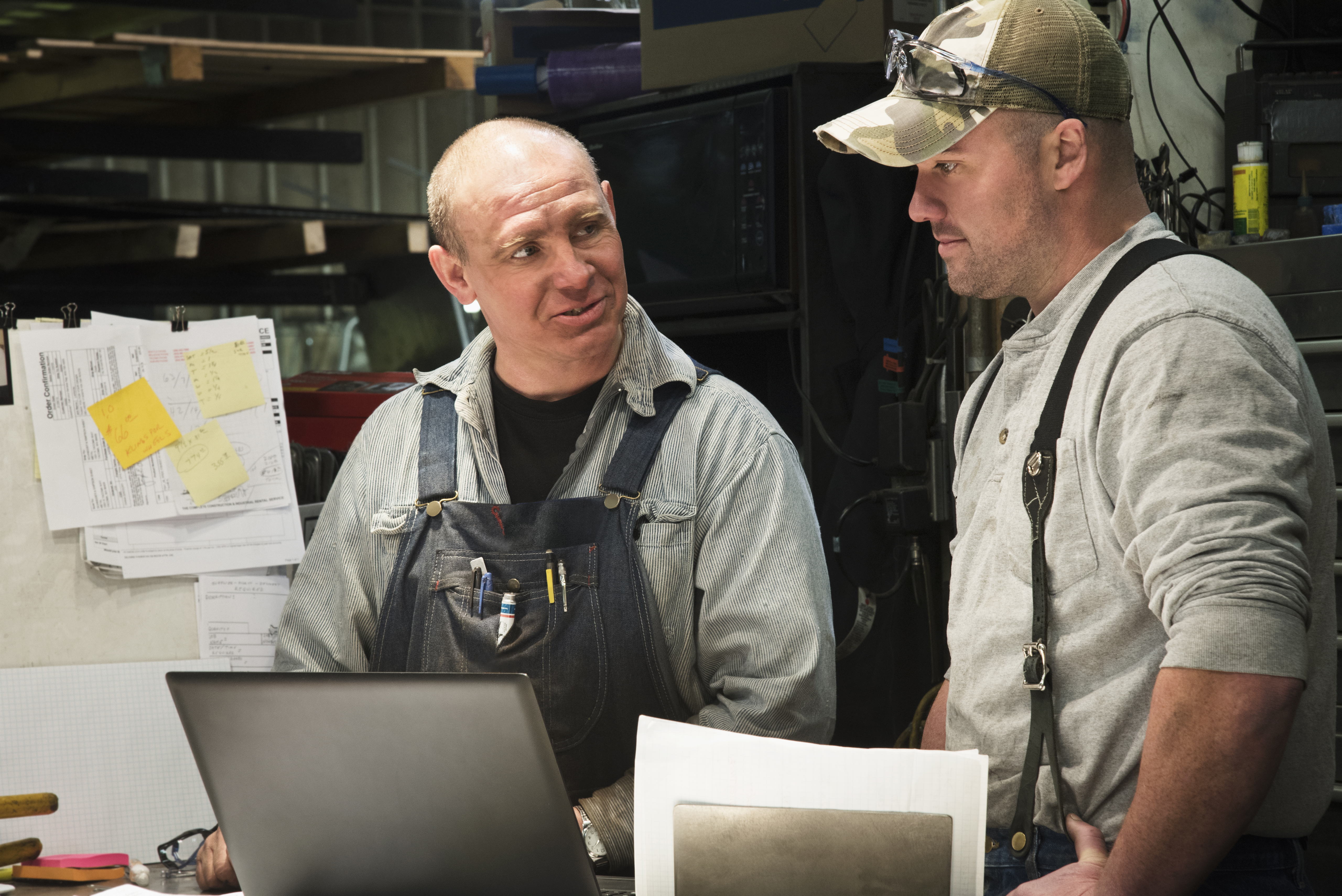 male workers using laptop in workshop