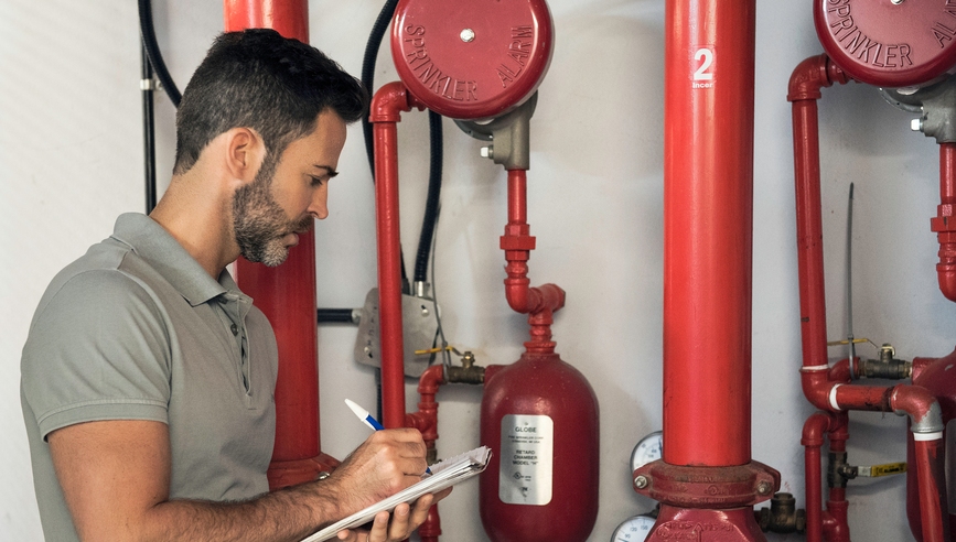 Man inspecting a fire protection sprinkler system.