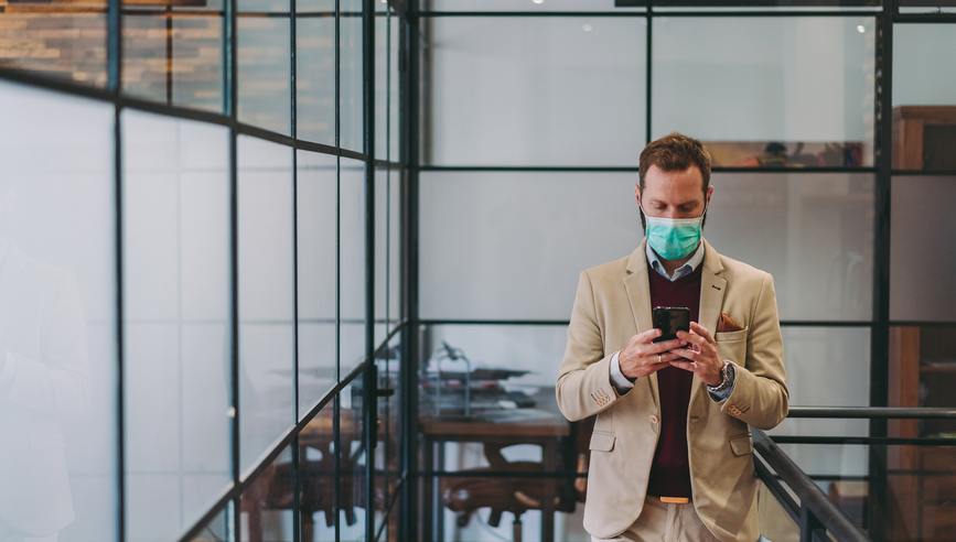 Businessman wearing mask in the office during COVID-19 pandemic; Safety in the office during COVID-19 pandemic, businesspeople with face masks