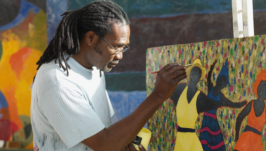 Man painting on a canvas.