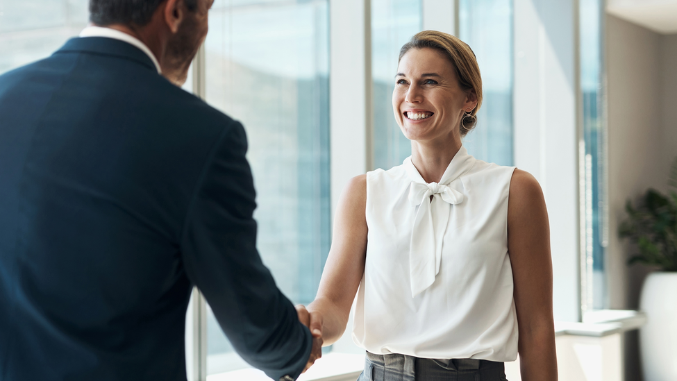 Handshake, meeting and business people partnership for b2b collaboration, onboarding welcome or professional opportunity. Corporate woman or clients shake hands for deal in office building interview