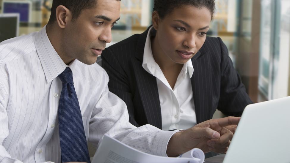 Businessman and businesswoman reviewing paperwork