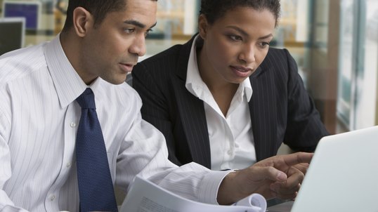 Two people looking at a laptop